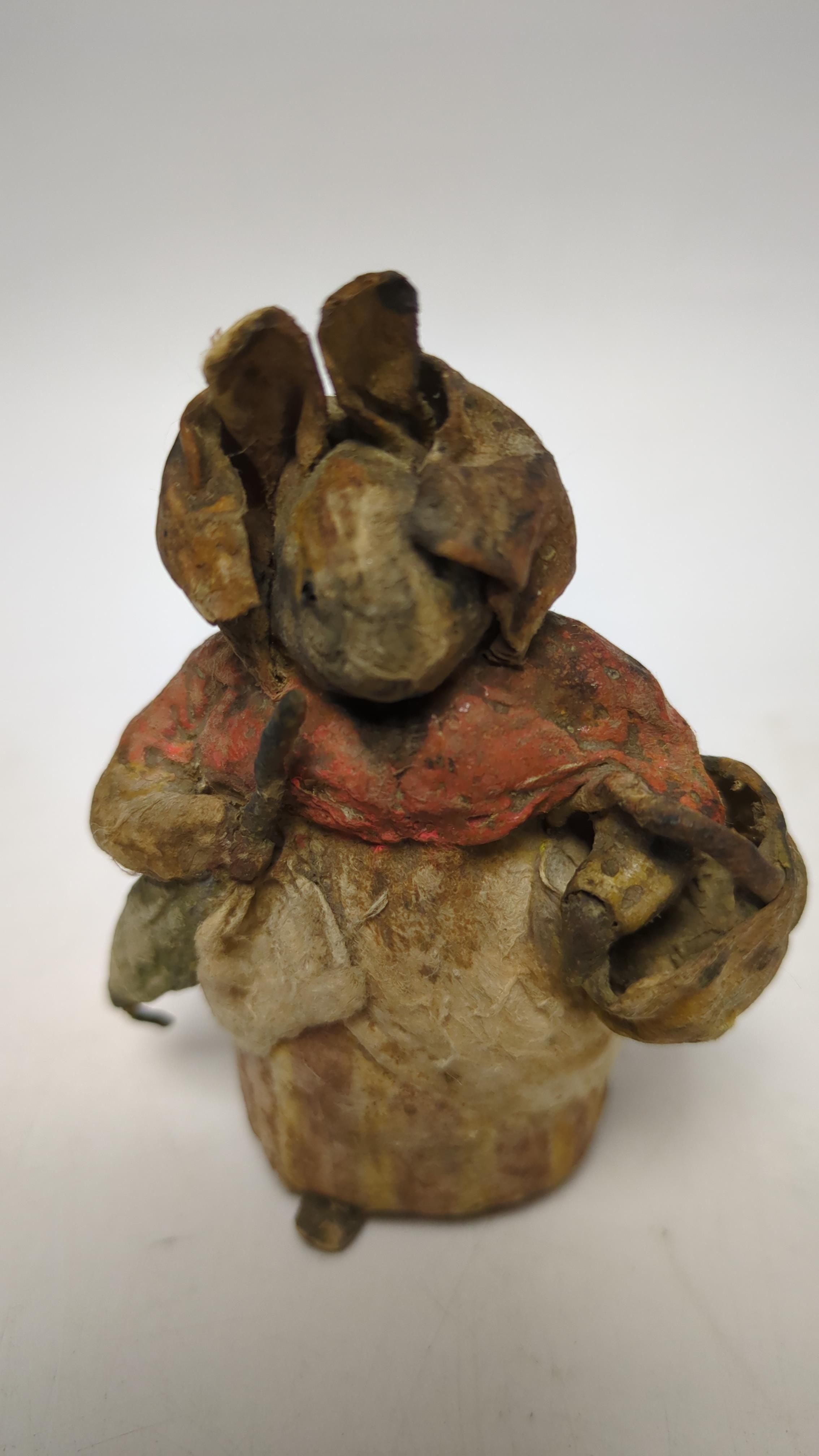 An F. Warne papier-mâché Beatrix Potter figure of Mrs. Rabbit with basket and umbrella, red and white F. Warne & Co. paper label to the base, dating it to pre-1917, 8.5cm high